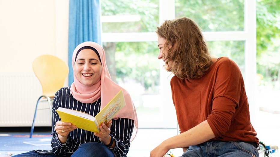 Foto: Antje Müller Zwei Frauen sitzen lachend auf dem Fußboden.