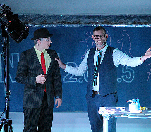 Zwei Darsteller unterhalten sich auf der Bühne.