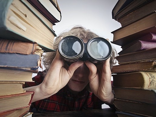 Anonyme Person Mit Fernglas, Die Durch Gestapelte Bücher Schaut