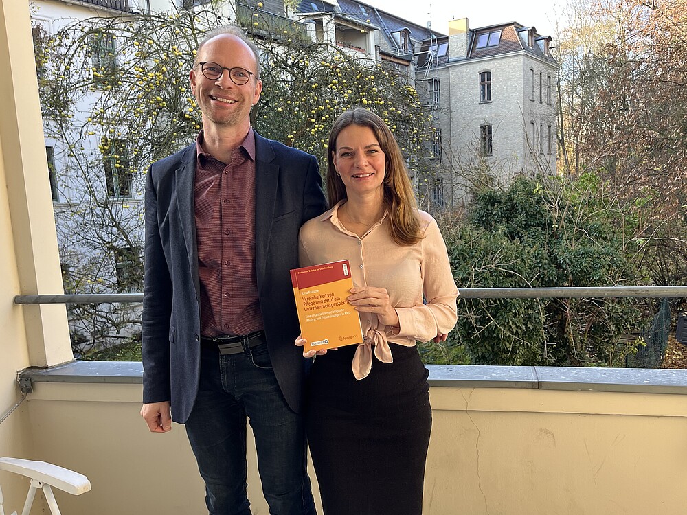 [Translate to Englisch:] Prof. Hoff und Katja Knauthe mit dem frisch gedruckten Buch