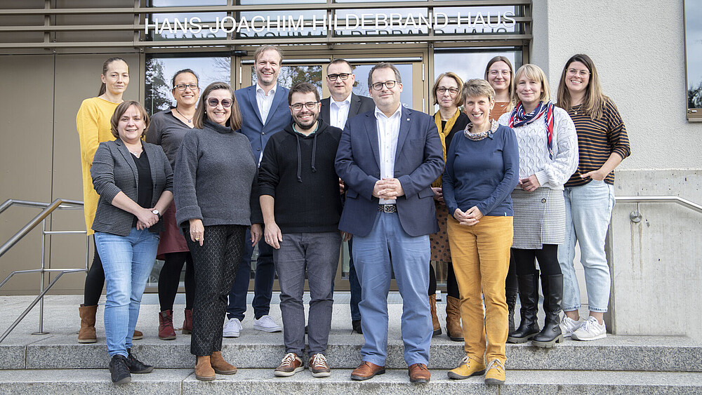 Workshopteilnehmende stehen auf dem Treppenaufgang vor Haus Z eins.