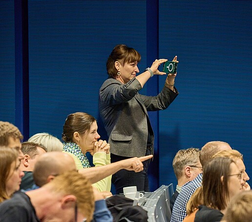 Eine Person fotografiert im Hörsaal