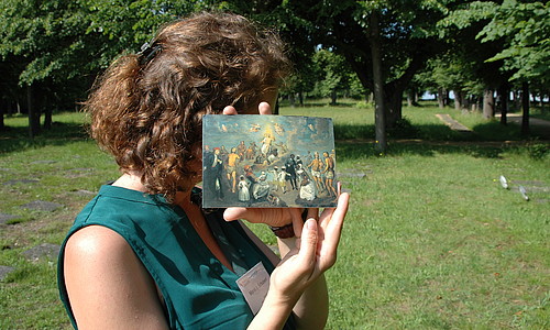 Frau hält Postkarte vor Gesicht