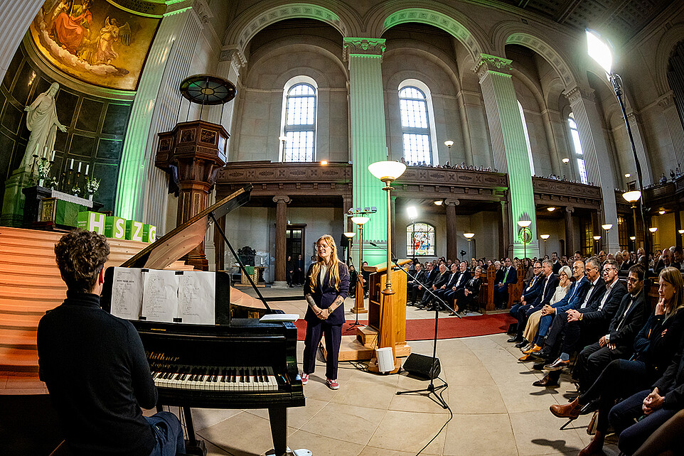 Victoria Hohlfeld steht neben Samuel Wagner am Flügel und singt vor dem Publikum der Johanniskirche.