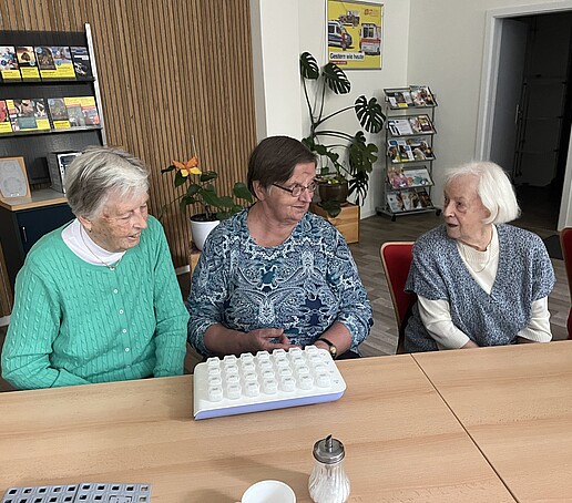 3 Damen begutachten eine Medikamentenbox