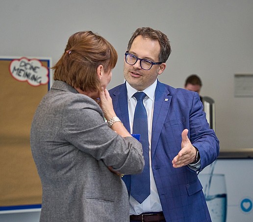 Zwei Personen (Rektor und Mitarbeiterin) im Gespräch. 