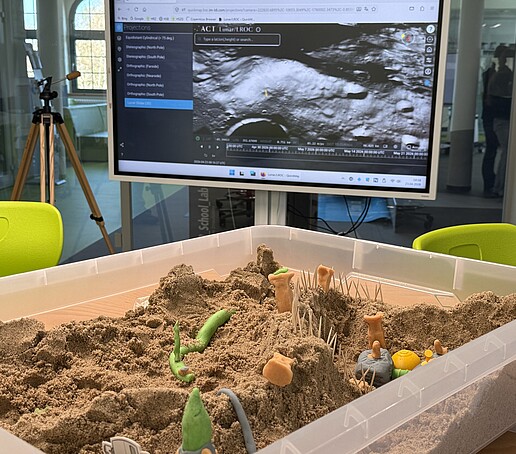 In einer Sandbox liegen aus Knetmasse geformte Mondsiedlungsbestandteile.