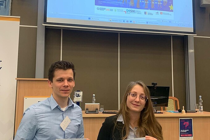 Zwei Nachwuchsforschende halten ein Zertifikat in den Händen.