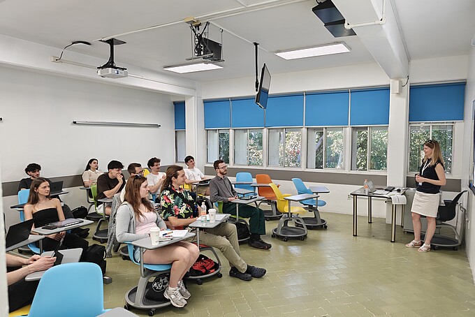 Patricia Stange hält Lehre vor vollbesetzten Lehrplätzen in einem Seminarraum.