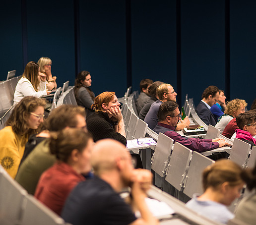 Viele Sitzreihen in einem Hörsaal sind besetzt.